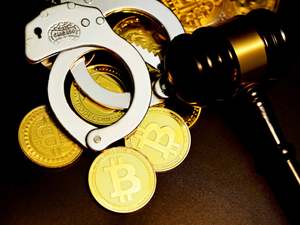 A handcuff is next to the hammer court on top of bitcoin
