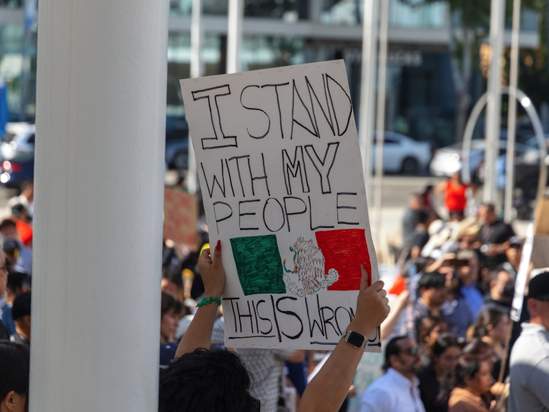 Protester holds a sign reading "i stand with my people".