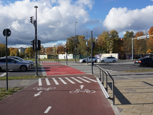 Red bike lane with white markings at intersection