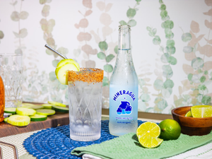 a table topped with bottles of alcohol and a bowl of limes