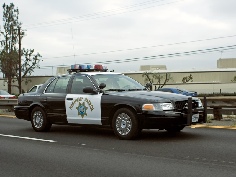 A california highway patrol car drives down the road.