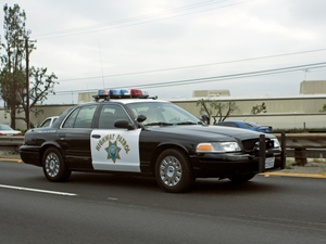 A california highway patrol car drives down the road.