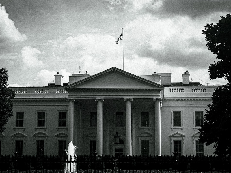 The white house stands under a cloudy sky.
