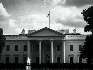 The white house stands under a cloudy sky.
