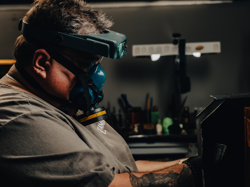 a man wearing a goggles while working on a piece of furniture