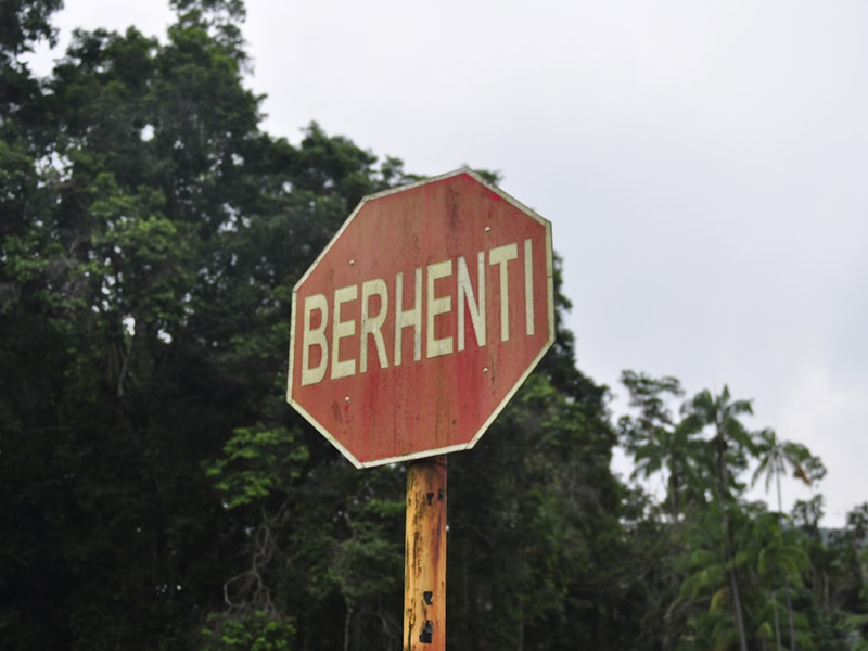 A red stop sign with the word 'berhenti'