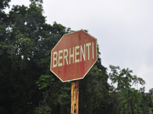 A red stop sign with the word 'berhenti'