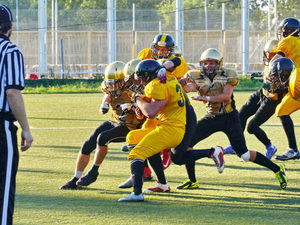 people playing american football with referee on the field during daytime