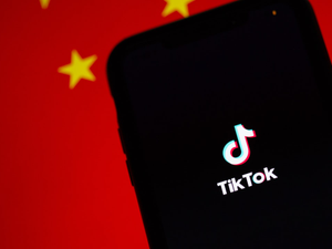 TikTok running on an iPhone. China's flag is displayed behind it.
