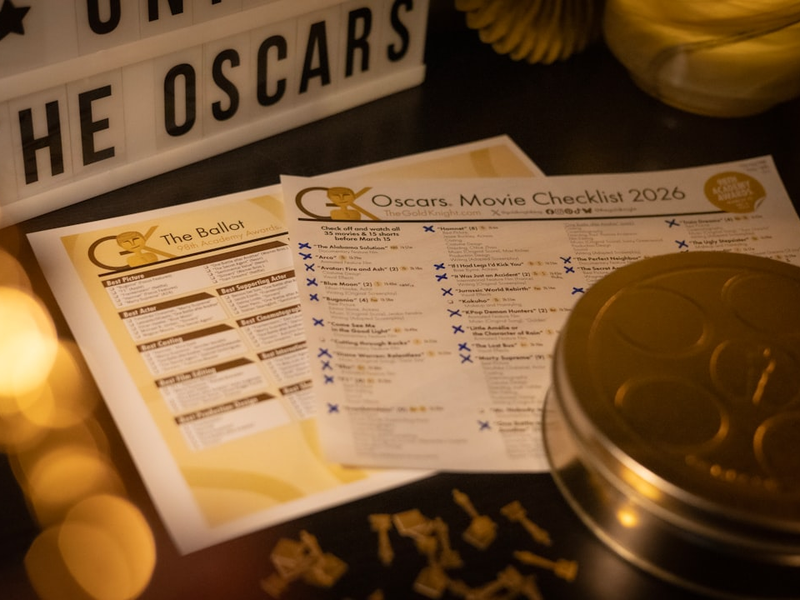 Excited for the 2026 Oscars, the 98th Academy Awards, with this collage. Printed 2026 Oscars ballot and movie checklist from TheGoldKnight.com on a table beside a lit lightbox reading The Oscars, with gold decorations. Also enjoyed playing with camera angles and using a small replica Oscar statuette for the bokeh effects.