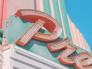 brown and white round frame on teal and pink concrete building