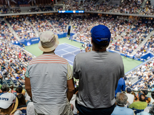 Two fans stand to cheer on tennis action during the 2022 US Open in New York City
