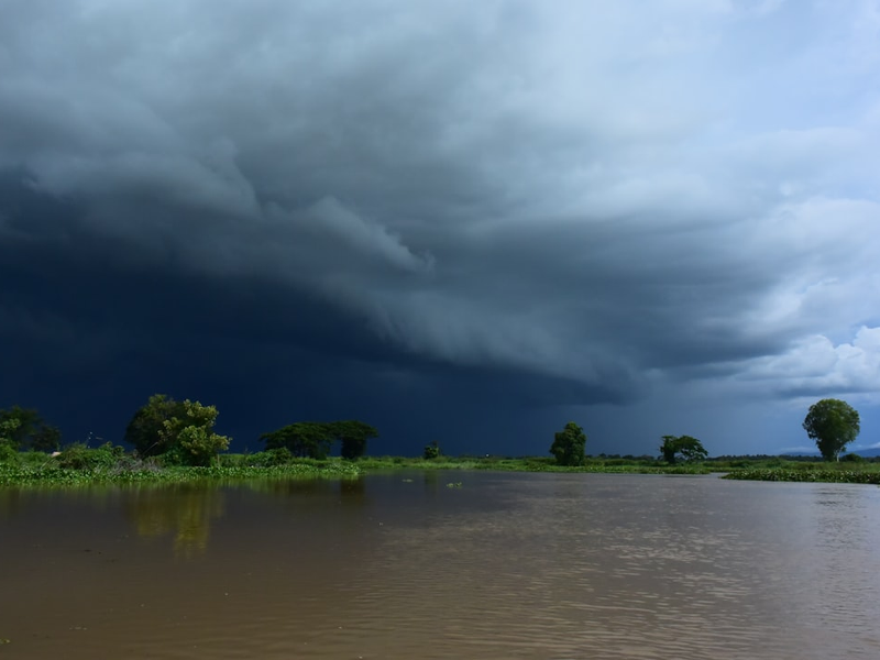 Dark storm clouds gather over a flooded landscape.