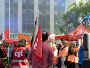 People holding flags at a rally with orange tents
