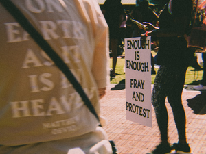 a group of people standing around each other holding signs