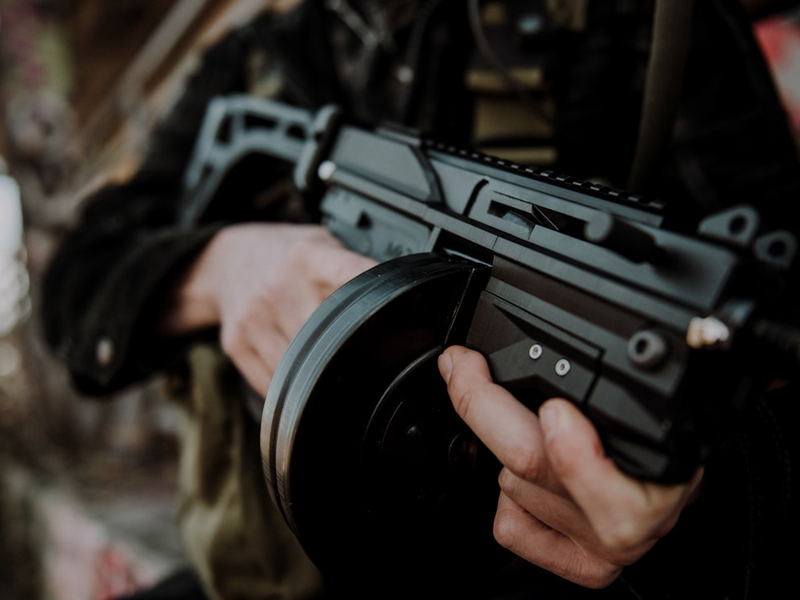 3D printed MAC-10 with drum magazine, being held by an unknown man.