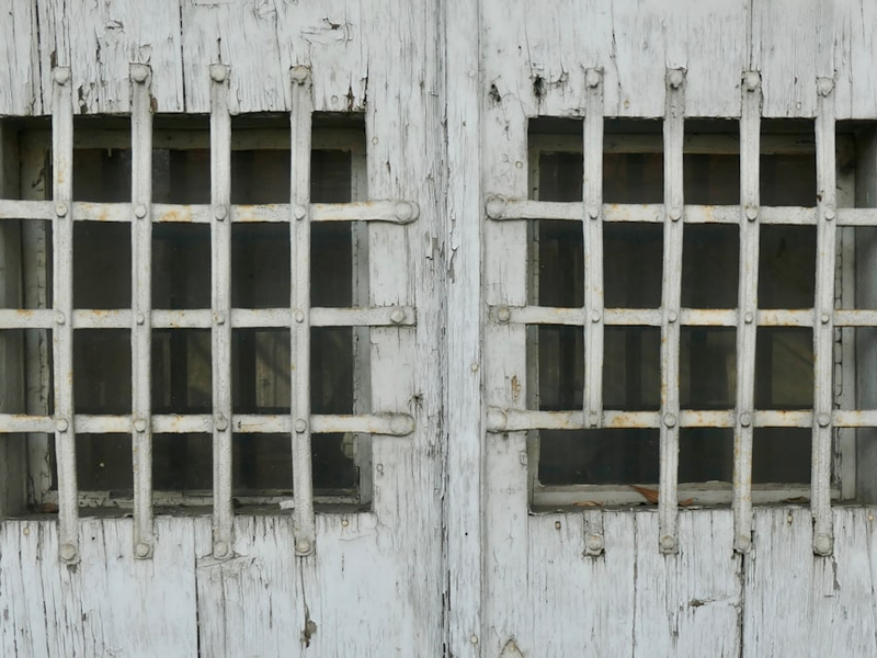 Two windows are covered with iron bars.