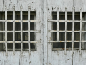 Two windows are covered with iron bars.
