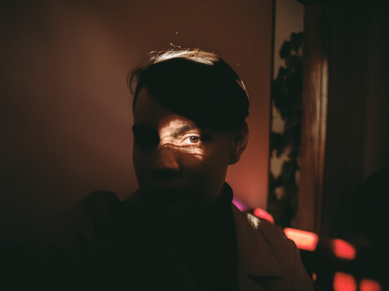 a man in a dark room with a light shining on his face