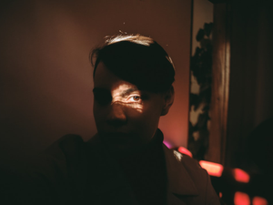 a man in a dark room with a light shining on his face