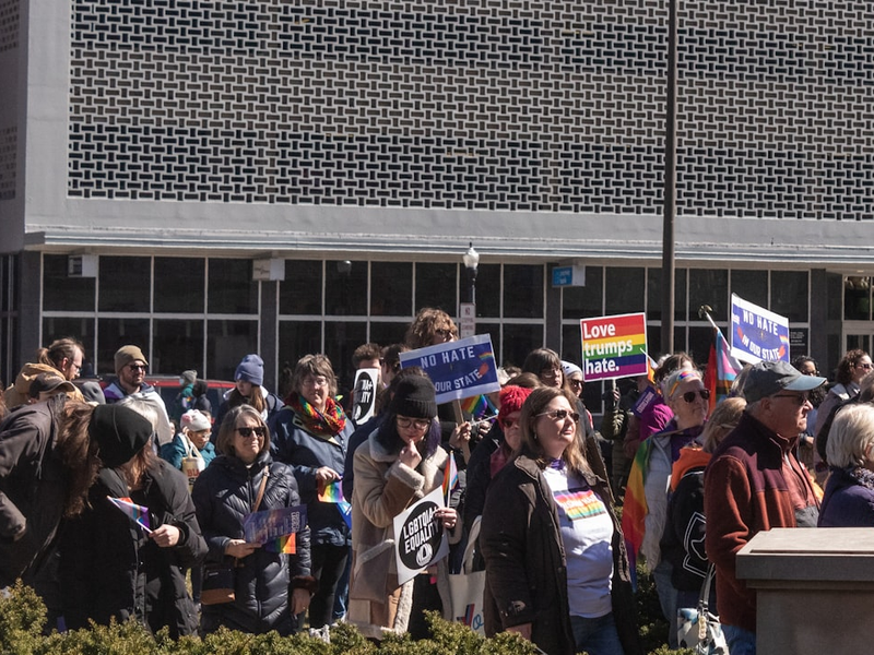 a crowd of people holding signs in front of a building