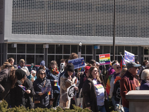 a crowd of people holding signs in front of a building