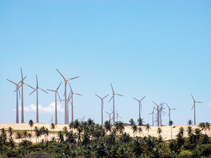 wind turbines on green grass field under blue sky during daytime