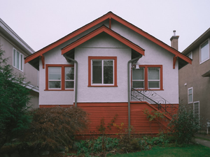 a red and white house with a red window
