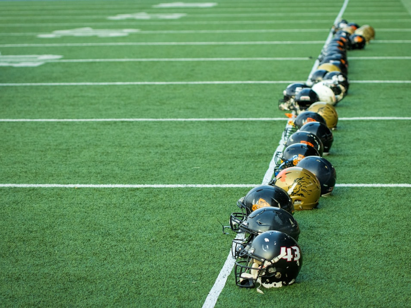 A line of football players lined up on the field