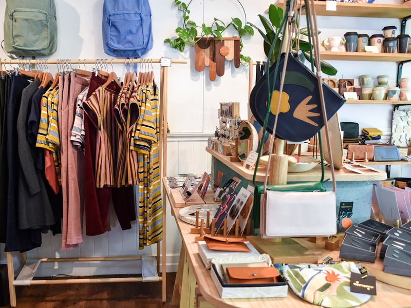 assorted-colored clothes on rack near brown wooden table