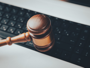 a wooden gaven sitting on top of a computer keyboard