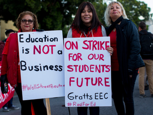 three women holding signges