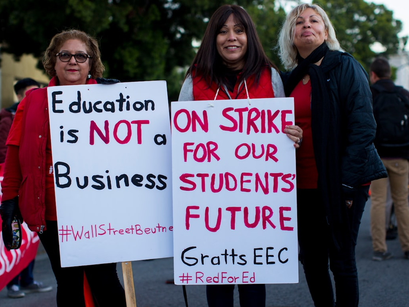 three women holding signges