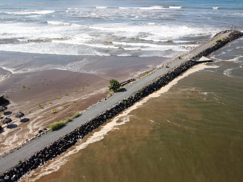 Long pier extending into the choppy ocean water
