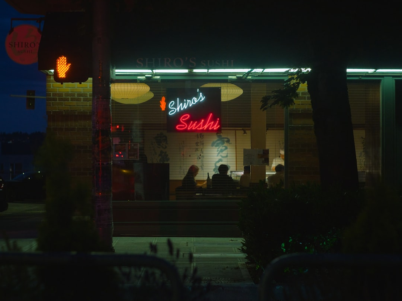 Sushi restaurant at night with neon lights.