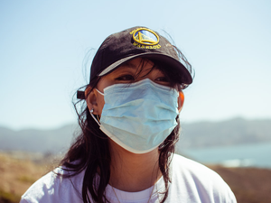 person wearing white crew neck shirt and black cap