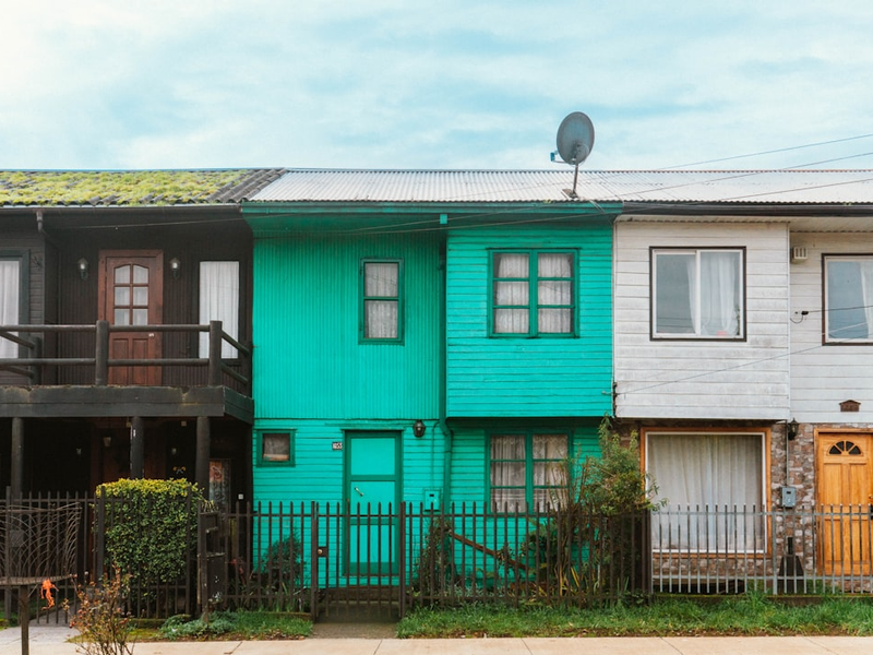 a row of multi - colored houses with a green roof