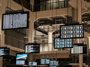 a bunch of television screens hanging from the ceiling