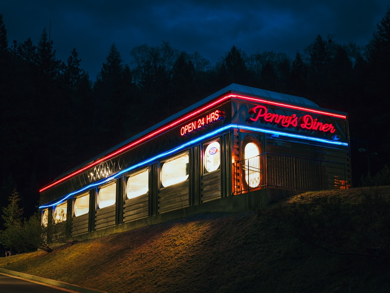 a lit up building on the side of a road
