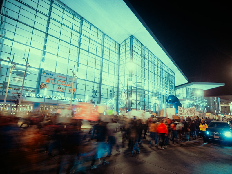 Crowd gathered outside a modern glass building at night