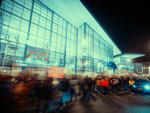 Crowd gathered outside a modern glass building at night