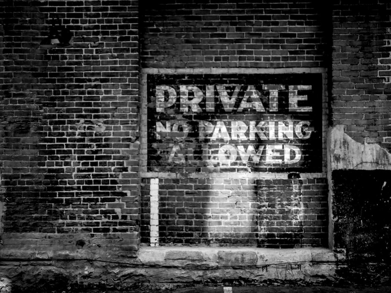 a black and white photo of a private parking sign