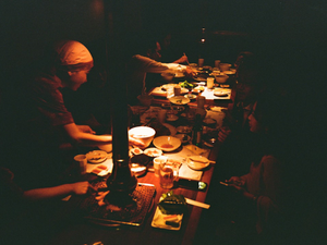 a group of people sitting at a table with plates of food