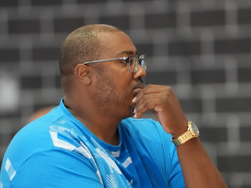 a man in a blue shirt with a watch on his left hand