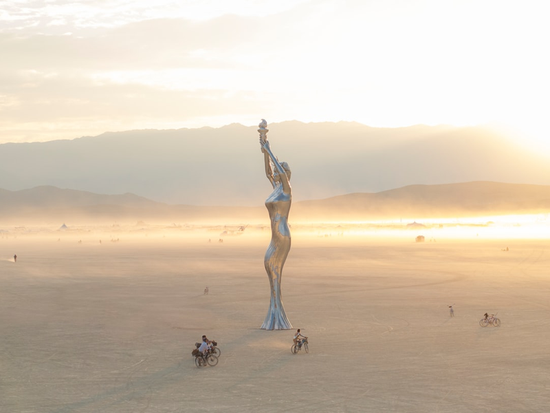 A statue of a woman in the middle of a desert