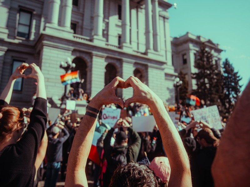 Protesters make hearts with their hands in support.
