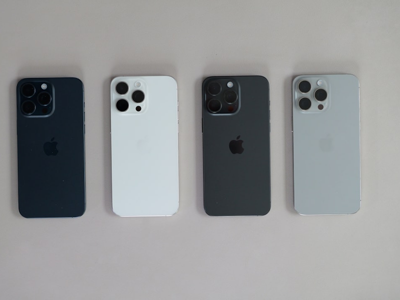 A group of four cell phones sitting next to each other