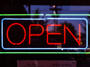 An illuminated OPEN sign in glaring red and framed by blue and green lines. Scanned from 35 mm slide film, shot in the city center of Vancouver, B.C., in August 2002.
