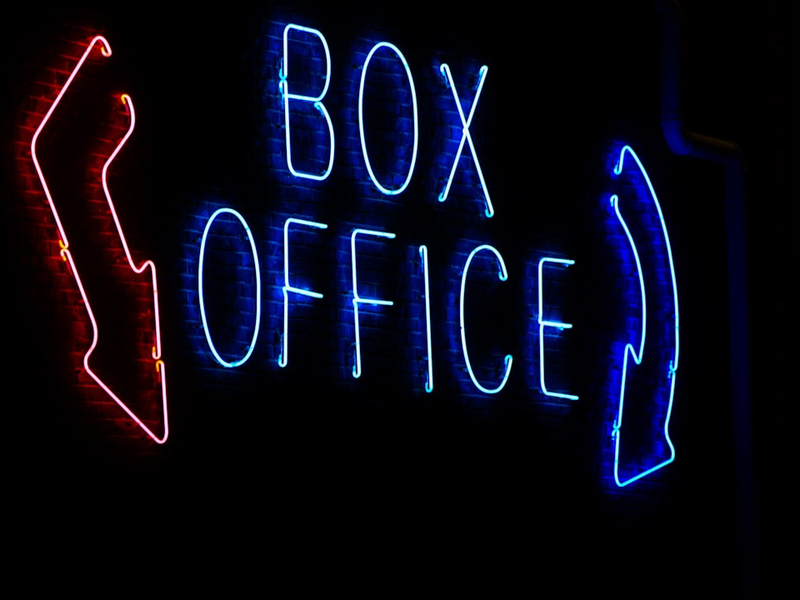 a box office sign lit up in the dark