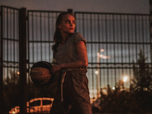 woman holding a black and white basketball ball